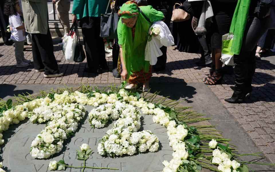 Les gens déposent des roses blanches au mémorial devant la porte ouest de l'abbaye de Westminster - Jonathan Brady / PA