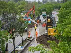 Les équipes de la ville construisent une berme sur Memorial Drive NW par le sentier de la rivière Bow pour protéger Sunnyside contre d'éventuelles inondations mardi.