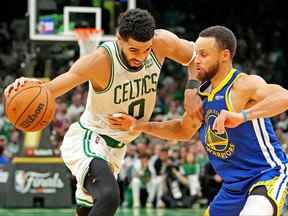 L'attaquant des Boston Celtics Jayson Tatum gère le ballon contre le gardien des Golden State Warriors Stephen Curry au cours du quatrième quart du sixième match de la finale de la NBA 2022 au TD Garden de Boston, le 16 juin 2022.