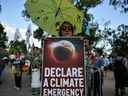 Des manifestants brandissent des pancartes devant le site de l'Open d'Australie lors d'un rassemblement de protestation climatique à Melbourne le 24 janvier 2020. – La crise des feux de brousse qui dure depuis des mois a suscité de nouveaux appels pour que le gouvernement conservateur australien prenne des mesures immédiates contre le changement climatique, avec des ministre Scott Morrison pour réduire la dépendance du pays au charbon.  (Photo de Manan VATSYAYANA / AFP) / IMAGE RESTRICTED TO EDITORIAL USE - STRICTEMENT NO COMMERCIAL USE (Photo de MANAN VATSYAYANA/AFP via Getty Images)