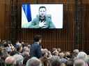 Le président ukrainien Volodymyr Zelenskyy pose sa main sur son cœur en écoutant le premier ministre Justin Trudeau avant le discours virtuel de Zelenskyy devant le Parlement canadien le 15 mars 2022.