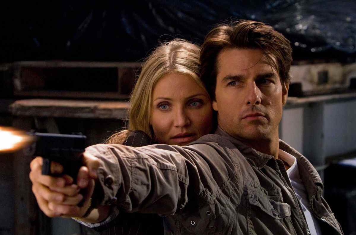 Tom Cruise et Cameron Diaz tiennent une arme ensemble dans Knight &  Jour