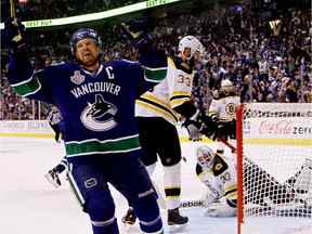 Henrik Sedin célèbre après que Daniel Sedin (pas sur la photo) ait marqué un but en troisième période contre Tim Thomas des Bruins de Boston lors du deuxième match de la finale de la Coupe Stanley 2011 de la LNH au Rogers Arena le 4 juin 2011.