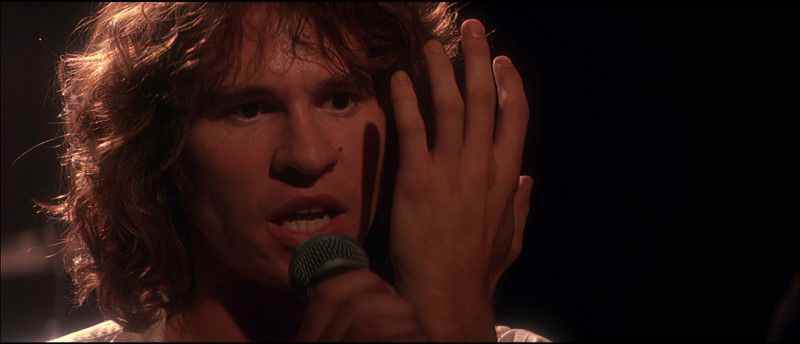 Val Kilmer dans le rôle de Jim Morrison, jouant dans The Doors.