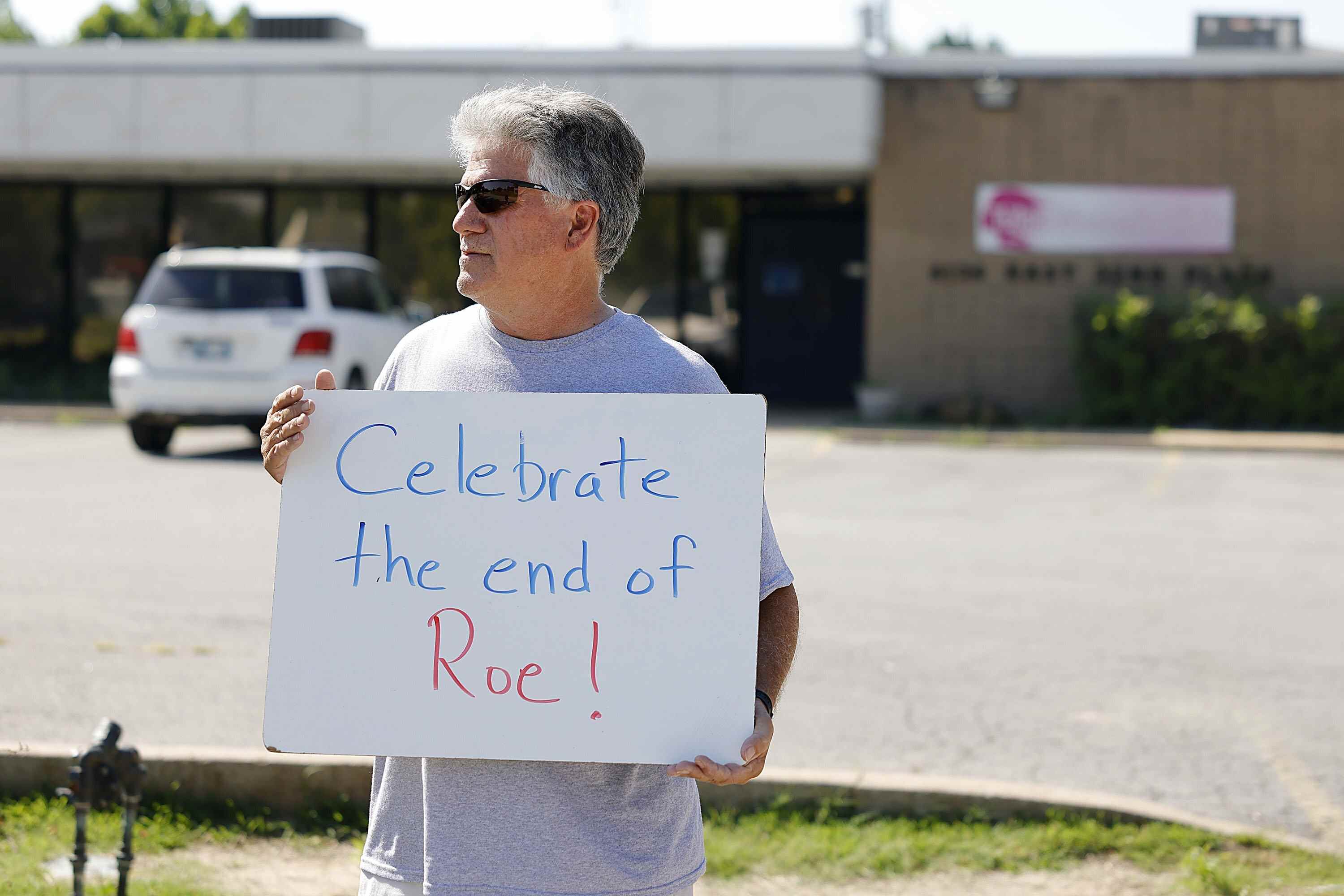 Tim Beach se tient devant la Tulsa Women's Clinic avec une pancarte célébrant la fin de Roe contre Wade le vendredi 24 juin 2022 à Tulsa, Okla. La Cour suprême a mis fin aux protections constitutionnelles de l'avortement qui étaient en place depuis près de 50 ans - une décision de sa majorité conservatrice d'annuler les affaires d'avortement historiques du tribunal.  Le résultat de vendredi annulant Roe v. Wade devrait conduire à des interdictions d'avortement dans environ la moitié des États.  (Mike Simons/Tulsa World via AP)