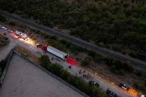 Dans cette vue aérienne, des membres des forces de l'ordre enquêtent sur un semi-remorque le 27 juin 2022 à San Antonio, Texas.  (Photo de Jordan Vonderhaar/Getty Images)