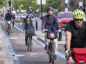 Des cyclistes descendent le REV — Réseau Express Vélo — sur la rue St-Denis pendant le trajet du matin à Montréal le 2 juin 2022.