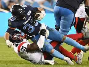 Le porteur de ballon des Argonauts de Toronto Andrew Harris (33 ans) est attaqué par le secondeur des Alouettes de Montréal Chris Ackie (21 ans) lors de la première deuxième action de football de la LCF à Toronto le jeudi 16 juin 2022.