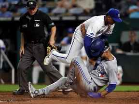 Lourdes Gurriel Jr. des Blue Jays de Toronto entre en collision avec le lanceur Albert Abreu # 69 des Royals de Kansas City alors qu'il se glisse dans le marbre pour marquer sur un terrain sauvage lors de la 8e manche du match au Kauffman Stadium le 06 juin 2022 à Kansas City, Missouri.