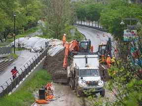 Les équipes de la ville construisent une berme sur Memorial Drive NW par le sentier de la rivière Bow pour protéger Sunnyside contre d'éventuelles inondations mardi.