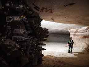 Un mineur se tient près de la tête de coupe d'une excavatrice près d'un mur minier actif à la mine de potasse Nutrien Ltd. Cory à Saskatoon, Sask.