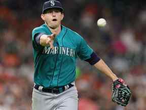 Chris Flexen # 77 des Mariners de Seattle retourne le ballon à Ty France # 23 faisant sortir Yuli Gurriel # 10 des Astros de Houston au premier but lors de la sixième manche au Minute Maid Park le 07 juin 2022 à Houston, Texas.