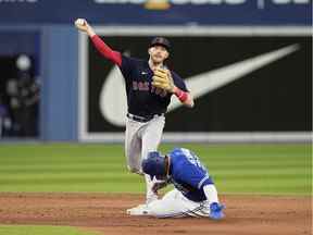 27 juin 2022 ;  Toronto, Ontario, CAN ;  Le joueur de deuxième but des Red Sox de Boston Trevor Story (10) lance au premier après avoir fait sortir le voltigeur droit des Blue Jays de Toronto Teoscar Hernandez (37) au deuxième but lors de la cinquième manche au Rogers Centre.