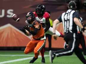 Bryan Burnham (16 ans) des BC Lions effectue la réception dans la zone des buts pour marquer un touché alors que Brad Muhammad des Redblacks d'Ottawa défend pendant la première moitié d'un match de football de la LCF à Vancouver, le samedi 11 septembre 2021.