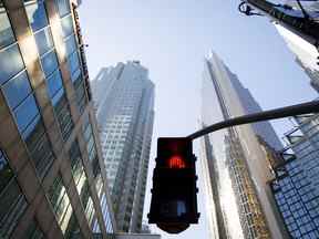 Un panneau de passage pour piétons clignote en rouge dans le quartier financier de Toronto.