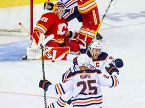 Le centre des Oilers d'Edmonton Connor McDavid (97) célèbre son but en prolongation contre le gardien des Flames de Calgary Jacob Markstrom (25), dans le cinquième match de la deuxième ronde des séries éliminatoires de la Coupe Stanley 2022 au Scotiabank Saddledome de Calgary le 26 mai.