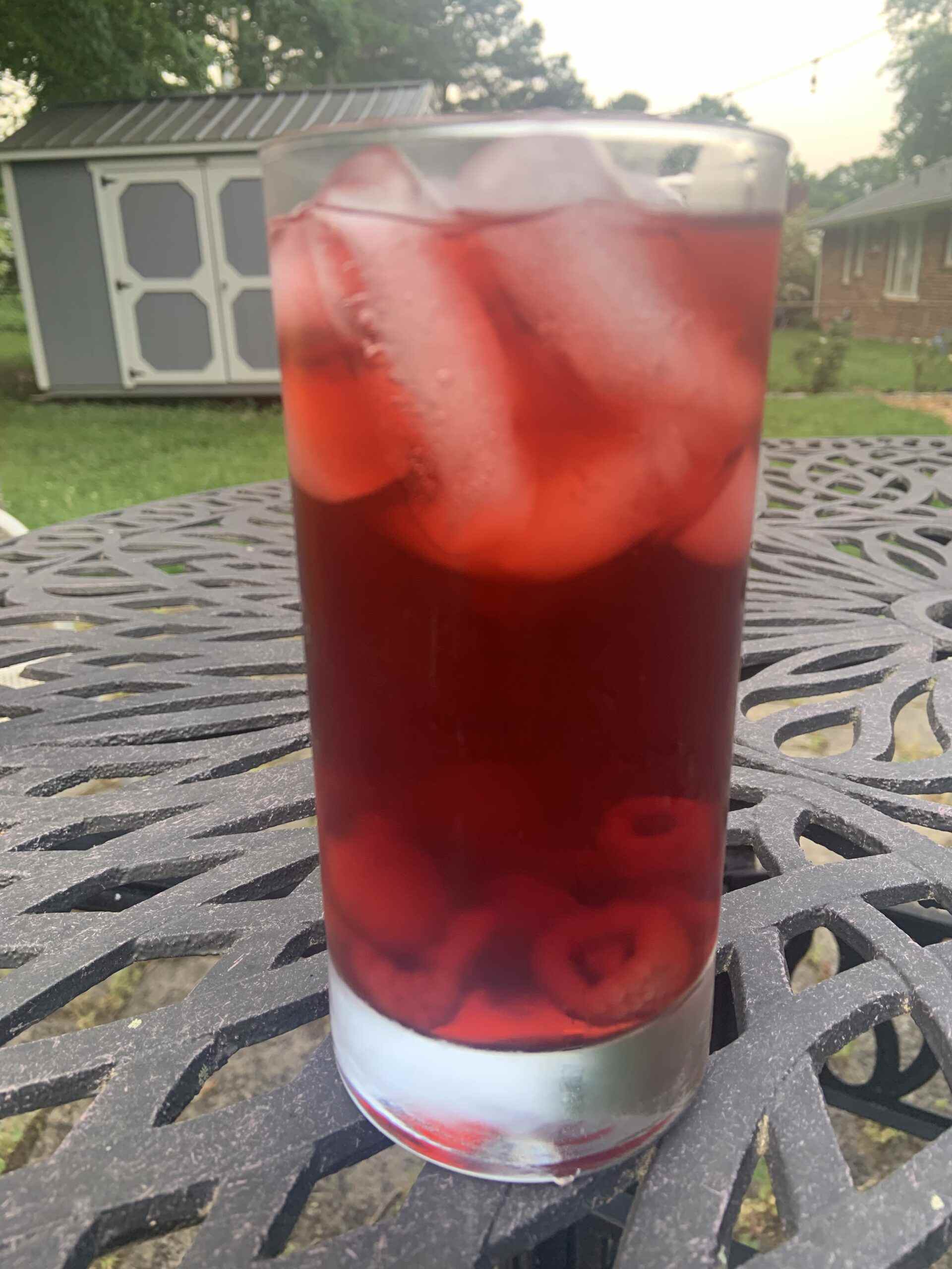 une photo d'un verre de thé glacé à la framboise