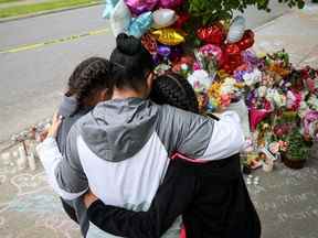 Les personnes en deuil se rassemblent à un mémorial des 10 morts lors de la fusillade du 14 mai 2022 dans un supermarché Tops à Buffalo, NY Les autorités ont déclaré que le tireur était motivé par une idéologie raciste nationaliste blanche connue sous le nom de théorie du «remplacement».