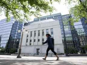 Une personne passe devant l'édifice de la Banque du Canada à Ottawa.