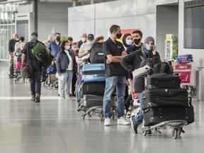 Les voyageurs font la queue au terminal 3 de l'aéroport Pearson de Toronto.