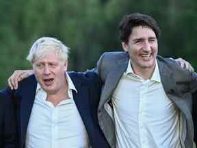 Le Premier ministre britannique Boris Johnson et le Premier ministre canadien Justin Trudeau s'amusent lors d'une photo de groupe des dirigeants lors du sommet du G7 au château d'Elmau, en Allemagne, le 26 juin 2022.