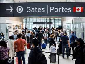 Les voyageurs envahissent la zone de sécurité de l'aéroport international Pearson de Toronto, le 20 mai 2022. REUTERS/Cole Burston