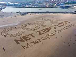 Une œuvre d'art géante en sable orne la plage de New Brighton pour souligner le réchauffement climatique et la conférence mondiale sur le climat Cop26 à Wirral, Merseyside.