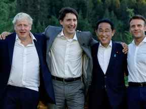 Le Premier ministre britannique Boris Johnson, le Premier ministre canadien Justin Trudeau, le Premier ministre japonais Fumio Kishida et le président français Emmanuel Macron posent pour une photo à côté d'un banc où la chancelière allemande Angela Merkel et le président américain Barack Obama ont été photographiés lors d'un sommet du G7 en 2015, lors de la première journée du sommet des dirigeants du G7 au château Schloss Elmau de Bavière, près de Garmisch-Partenkirchen, Allemagne, le 26 juin 2022.