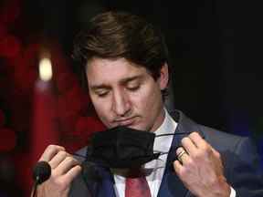 Le premier ministre Justin Trudeau enlève son masque avant de répondre aux questions lors d'une annonce à Ottawa, le mercredi 15 décembre 2021.