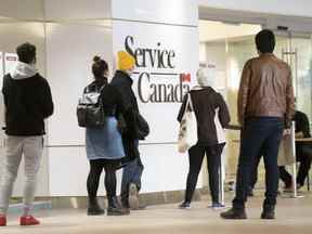 Des gens font la queue dans un bureau de Service Canada à Montréal le jeudi 19 mars 2020.