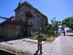 Un militaire russe patrouille sur le territoire du port maritime de la ville de Marioupol le 12 juin 2022, au milieu de l'action militaire russe en cours en Ukraine.