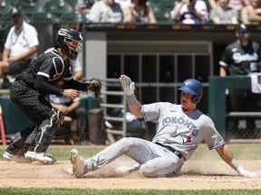 Le joueur de troisième but des Blue Jays de Toronto, Matt Chapman, glisse en toute sécurité dans la maison alors que le receveur des White Sox de Chicago, Reese McGuire, est incapable de le marquer lors de la quatrième manche au terrain à taux garanti.