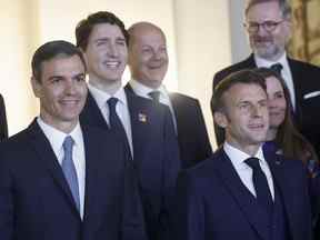 Le Premier ministre espagnol Pedro Sanchez, à gauche, le président français Emmanuel Macron, le Premier ministre canadien Justin Trudeau, au centre à gauche, le chancelier allemand Olaf Scholz, au centre, le Premier ministre tchèque Petr Fiala et le Premier ministre islandais Katrin Jakobsdottir posent pour une photo de groupe avec le roi d'Espagne Felipe et la reine Letizia et les dirigeants de l'OTAN avant un dîner de gala au Palais Royal de Madrid, en Espagne, le mardi 28 juin 2022.