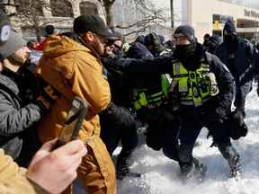 La police repousse lors d'un ratissage contre la manifestation du Freedom Convoy à Ottawa, le 18 février 2022.