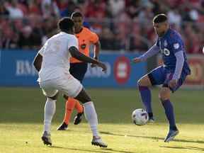 Le milieu de terrain du Toronto FC Alejandro Pozuelo contrôle le ballon contre le défenseur des Chicago Fire Carlos Teran au cours de la première mi-temps au BMO Field.