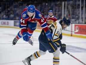 Carter Souch (44 ans) des Oil Kings d'Edmonton prend son envol après avoir été mis en échec par Loris Rafanomezantsoa (15 ans) des Cataractes de Shawinigan lors de la première période de la Coupe Memorial 2022, le 21 juin 2022, à la Harbour Station de Saint John, au Nouveau-Brunswick.