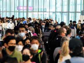 Les voyageurs se pressent dans la file d'attente de sécurité dans la salle des départs au début du long week-end de la fête de Victoria à l'aéroport international Pearson de Toronto à Mississauga, Ontario, Canada, le 20 mai 2022.