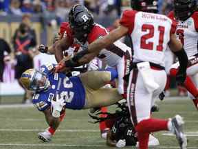 Brady Oliveira des Blue Bombers s'est fait plaquer par Avery Williams des Redblacks d'Ottawa hier soir.  John Woods/LA PRESSE CANADIENNE