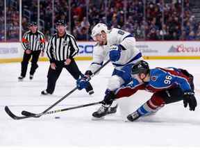 Le défenseur du Lightning de Tampa Bay Erik Cernak (81) et l'ailier droit de l'Avalanche du Colorado Mikko Rantanen (96) se battent pour la rondelle en première période au Pepsi Center.