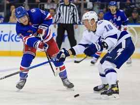 1er juin 2022 ;  New York, New York, États-Unis ;  Le défenseur des Rangers de New York Adam Fox (23) passe la rondelle autour de l'aile gauche du Lightning de Tampa Bay Ondrej Palat (18) dans la troisième période du premier match de la finale de la Conférence de l'Est des séries éliminatoires de la Coupe Stanley 2022 au Madison Square Garden.