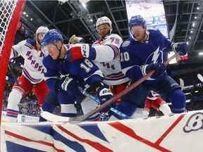 Ondrej Palat # 18 et Corey Perry # 10 du Lightning de Tampa Bay cherchent la rondelle alors qu'Igor Shesterkin # 31 des Rangers de New York effectue un arrêt en plongeon au cours de la première période du quatrième match de la finale de la Conférence de l'Est des séries éliminatoires de la Coupe Stanley 2022 à Amalie Arena le 07 juin 2022 à Tampa, en Floride.