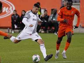 Le milieu de terrain du Toronto FC Alejandro Pozuelo (10) lance le ballon contre le défenseur du Forge FC Ashtone Morgan.