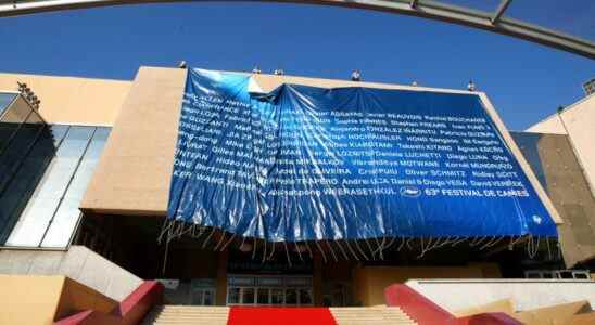 Workers set up a giant canvas of the 63rd Cannes Film Festival's official poster on the Cannes Festival Palace, Monday, May 10, 2010. The Cannes Film Festival  will start on May 12.(AP Photo/Lionel Cironneau)