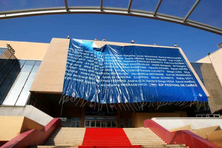 Workers set up a giant canvas of the 63rd Cannes Film Festival's official poster on the Cannes Festival Palace, Monday, May 10, 2010. The Cannes Film Festival  will start on May 12.(AP Photo/Lionel Cironneau)