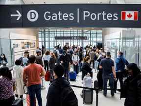 Les voyageurs se pressent dans la file d'attente de sécurité dans la salle des départs de l'aéroport international Pearson de Toronto le 20 mai.