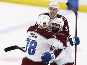 L'attaquant de l'Avalanche Nazem Kadri, à droite, célèbre avec Nico Sturm, à gauche, et Jack Johnson après avoir marqué un but en prolongation pour vaincre le Lightning 3-2 lors du quatrième match de la finale de la Coupe Stanley de la LNH à l'Amalie Arena de Tampa, en Floride, mercredi, 22 juin 2022.