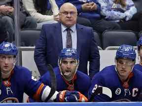 DOSSIER – L'entraîneur-chef des Islanders de New York, Barry Trotz, en tête, assiste à la troisième période d'un match de hockey de la LNH contre le Wild du Minnesota, le 30 janvier 2022, à Elmont, NY Une brasserie de Winnipeg dit qu'elle donnera à Trotz de la bière gratuite à vie s'il retourne dans sa province natale pour entraîner les Jets.