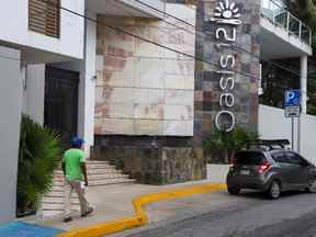 Un homme passe devant le condo Oasis 12 où deux citoyens canadiens, un homme et une femme, ont été tués par des assaillants inconnus, ont annoncé les autorités mardi, à Playa del Carmen, au Mexique, le 21 juin 2022. REUTERS/Stringer