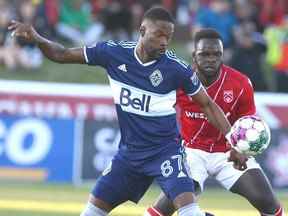 Tosaint Ricketts (L) des Whitecaps et le défenseur du Cavalry FC Karifa Yao se battent pour un ballon lâche lors de l'action de soccer du Championnat canadien contre les Whitecaps de Vancouver à Calgary le mercredi 25 mai 2022.