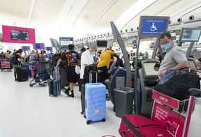 Les gens font la queue pour s'enregistrer à l'aéroport international Pearson de Toronto le jeudi 12 mai 2022.